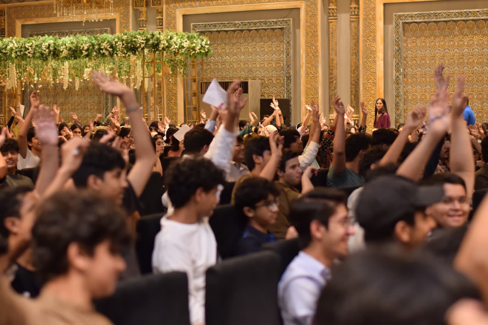 Engaged students with hands raised during a workshop